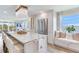 Elegant kitchen island features seating, modern stainless appliances, a decorative light fixture, and a window seat at 100 Oakmont Ln # 310, Belleair, FL 33756