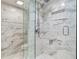 Marble tiled walk-in shower featuring dual shower heads, niche, and frameless glass enclosure at 100 Oakmont Ln # 310, Belleair, FL 33756