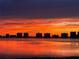 Beautiful view of a city skyline at sunset over the water, featuring vibrant orange and red colors at 100 Oakmont Ln # 310, Belleair, FL 33756