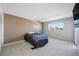 A cozy bedroom featuring a wood-panel accent wall, plush carpet, and a bright window view at 10216 Regal Dr # 208, Largo, FL 33774