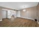 Open living space featuring wood-look floors, a modern light fixture and neutral wall colors at 10216 Regal Dr # 208, Largo, FL 33774