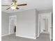 Bedroom with neutral walls, gray carpet and ceiling fan with views into hallway at 1028 Oliveto Verdi Ct, Brandon, FL 33511