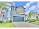 Two-story home featuring an attached two-car garage, with palm trees and manicured landscaping at 1028 Oliveto Verdi Ct, Brandon, FL 33511