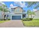 Two-story home featuring an attached two-car garage, with palm trees and manicured landscaping at 1028 Oliveto Verdi Ct, Brandon, FL 33511