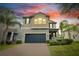 Two-story home featuring an attached two-car garage, with palm trees and manicured landscaping at 1028 Oliveto Verdi Ct, Brandon, FL 33511
