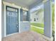 Covered front porch featuring brick flooring, gray stucco siding, and a teal entry door at 1028 Oliveto Verdi Ct, Brandon, FL 33511