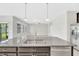 The kitchen island features granite countertops and overlooks the dining area and Gathering room at 1028 Oliveto Verdi Ct, Brandon, FL 33511