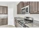 Close up on the kitchen with granite countertops, a stainless steel oven, and dark-stained cabinets at 1028 Oliveto Verdi Ct, Brandon, FL 33511
