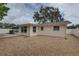 The back of the property featuring neutral siding, gravel landscaping, and a fence creating a clean and private yard at 11188 64Th Ter, Seminole, FL 33772