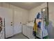 This is a laundry room with a washer, dryer and storage shelves filled with laundry detergents and cleaning products at 11188 64Th Ter, Seminole, FL 33772