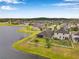 Expansive aerial view of the home and backyard with white fence facing a peaceful pond at 11878 Thicket Wood Dr, Riverview, FL 33579