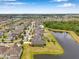 Expansive aerial view showcases the neighborhood homes with mature trees and a large pond at 11878 Thicket Wood Dr, Riverview, FL 33579