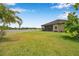 Expansive backyard with a pristine white fence, lush green lawn, and tranquil lake views at 11878 Thicket Wood Dr, Riverview, FL 33579