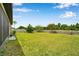 Spacious backyard with a well-kept lawn, white fence, and lush greenery providing a serene outdoor space at 11878 Thicket Wood Dr, Riverview, FL 33579