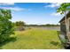 Lush backyard with well-manicured lawn and peaceful waterfront view with a white picket fence at 11878 Thicket Wood Dr, Riverview, FL 33579