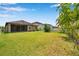 Expansive backyard featuring lush green grass, a charming white fence, and neighboring houses at 11878 Thicket Wood Dr, Riverview, FL 33579
