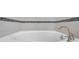 Close-up of a soaking tub with tile surround and sleek, modern fixtures at 11878 Thicket Wood Dr, Riverview, FL 33579