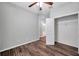 Bedroom featuring wood flooring, ceiling fan, closet, and bathroom access at 11878 Thicket Wood Dr, Riverview, FL 33579