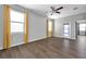 Bedroom featuring wood floors, 2 large windows with bright yellow curtains and a glass door for outside access at 11878 Thicket Wood Dr, Riverview, FL 33579