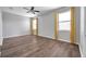 Bedroom featuring wood floors and two large windows dressed with bright yellow curtains at 11878 Thicket Wood Dr, Riverview, FL 33579