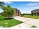 Beautiful home with a spacious driveway, green lawn, and scenic water view in a quiet neighborhood at 11878 Thicket Wood Dr, Riverview, FL 33579