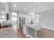 Modern kitchen island features stainless appliances, white cabinets and granite countertop at 11878 Thicket Wood Dr, Riverview, FL 33579