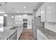 Modern kitchen featuring white cabinets, stainless steel appliances, and a large granite island at 11878 Thicket Wood Dr, Riverview, FL 33579