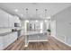 Bright, open kitchen featuring stainless appliances, white cabinets and a granite island at 11878 Thicket Wood Dr, Riverview, FL 33579