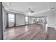 Open-concept living room with hardwood floors, modern ceiling fan, and seamless connection to the kitchen at 11878 Thicket Wood Dr, Riverview, FL 33579