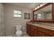 Bathroom featuring a granite vanity with cabinets, updated fixtures, large mirror, and a toilet with a paper holder at 11991 104Th Ave, Seminole, FL 33778