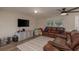 Cozy living room with hardwood floors, comfortable seating, a ceiling fan, and ample natural light at 11991 104Th Ave, Seminole, FL 33778