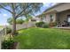 A well-manicured backyard features a vibrant green lawn, mature landscaping, and a tranquil setting for outdoor enjoyment at 12009 Whistling Wind Dr, Riverview, FL 33569