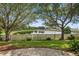 Lush backyard view of a pond surrounded by mature trees and a white picket fence at 12009 Whistling Wind Dr, Riverview, FL 33569