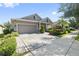 Charming home exterior with a two-car garage, manicured landscaping, and inviting curb appeal in a lovely neighborhood at 12009 Whistling Wind Dr, Riverview, FL 33569