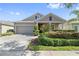 Charming single-Gathering home featuring a well-manicured front yard, two-car garage, and a covered entranceway at 12009 Whistling Wind Dr, Riverview, FL 33569