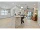 Open concept kitchen with granite counters, breakfast bar, and stainless steel appliances, seamlessly flowing into the living area at 12009 Whistling Wind Dr, Riverview, FL 33569