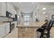 Modern kitchen featuring granite countertops, stainless steel appliances, and custom cabinets with a breakfast bar at 12009 Whistling Wind Dr, Riverview, FL 33569