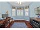 Bright office featuring a ceiling fan, wooden floors, blue walls, and a large window with a patterned valance at 12009 Whistling Wind Dr, Riverview, FL 33569