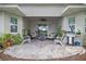 Relaxing covered patio with a seating area and a grill, surrounded by lush greenery at 12009 Whistling Wind Dr, Riverview, FL 33569