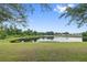 A serene pond view showcases a tranquil body of water surrounded by lush greenery and trees, offering a peaceful setting at 12009 Whistling Wind Dr, Riverview, FL 33569