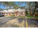 Exterior view of townhome with visible parking and grassy lawn featuring brick and siding, white trimmed windows and doorway at 12780 N 57Th St, Tampa, FL 33617