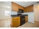 Kitchen with stainless steel appliances, wood cabinetry, dark countertops, and view of bright room with large window at 12780 N 57Th St, Tampa, FL 33617