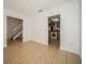 Bright living room with tile floors, white walls, crown molding, and view to the kitchen with washer and dryer at 12780 N 57Th St, Tampa, FL 33617