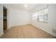 Bright living room with tile floors, white walls, large window, and crown molding detailing at 12780 N 57Th St, Tampa, FL 33617