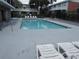 Community pool surrounded by lounge chairs and wrought iron fencing providing leisure and relaxation at 12780 N 57Th St, Tampa, FL 33617