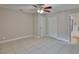 This bedroom features tile floors, neutral paint, a ceiling fan, and an ensuite bathroom at 13125 Wilcox Rd # 16202, Largo, FL 33774