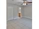 This bedroom features tile floors, neutral paint, a ceiling fan, and an ensuite bathroom at 13125 Wilcox Rd # 16202, Largo, FL 33774