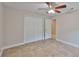 Bedroom featuring neutral paint, tile floors, a ceiling fan, and a closet at 13125 Wilcox Rd # 16202, Largo, FL 33774
