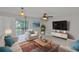 Bright living room featuring a ceiling fan, tile flooring, a large window, and neutral color scheme at 13125 Wilcox Rd # 16202, Largo, FL 33774