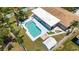 Aerial view of a backyard featuring a pool, shed, tropical foliage, and proximity to the main home at 1530 Picardy Cir, Clearwater, FL 33755